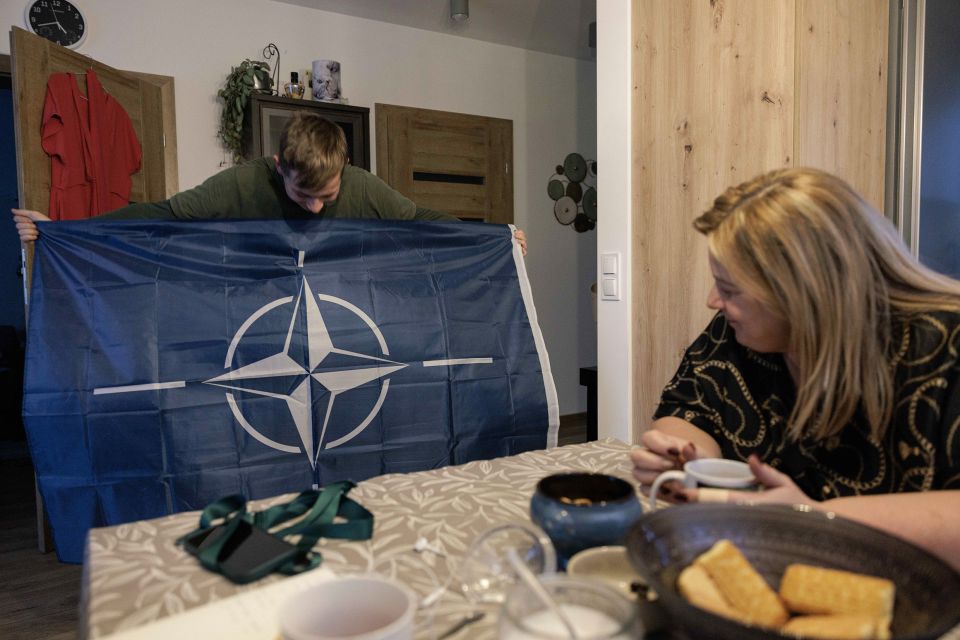 Kuba Żebrowski zeigt eine Nato-Flagge mit seiner Mutter Beata Żebrowska
