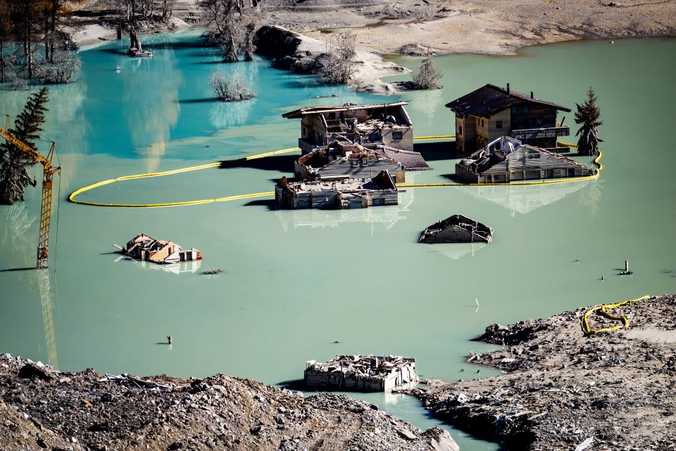 der Schuttkegel des Bergsturzes vom 28. Mai hat die Lonza zu einem See aufgestaut, darin stehen Häuser und ein Baukran im Wasser