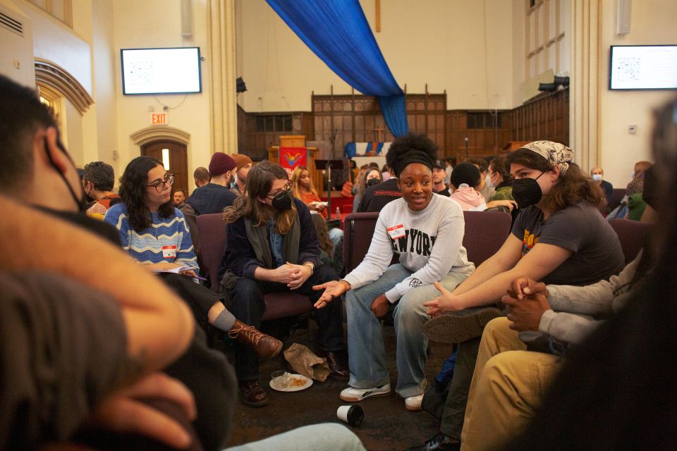 Josie Wells diskutiert in einer Kirche mit mehreren Personen