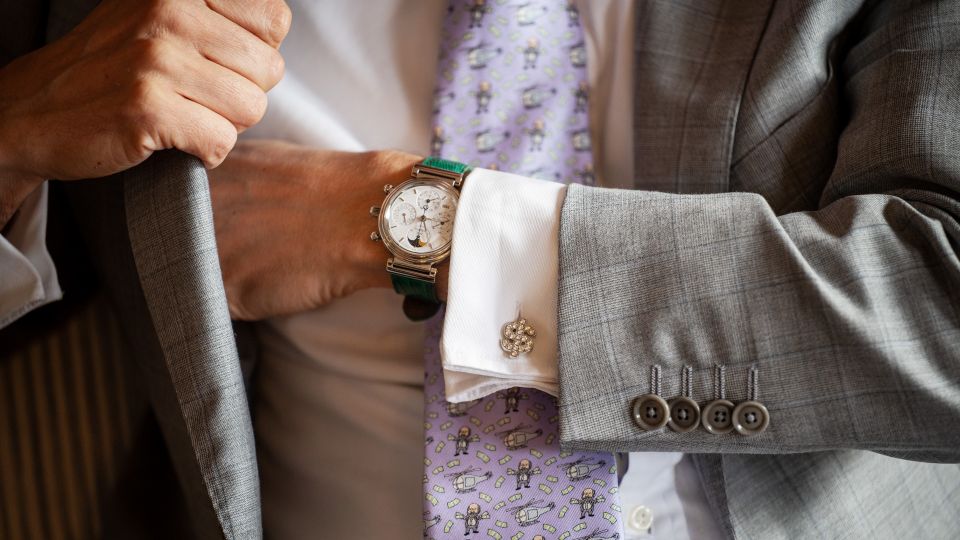 eine Person in Anzug und Krawatte trägt eine teure Uhr