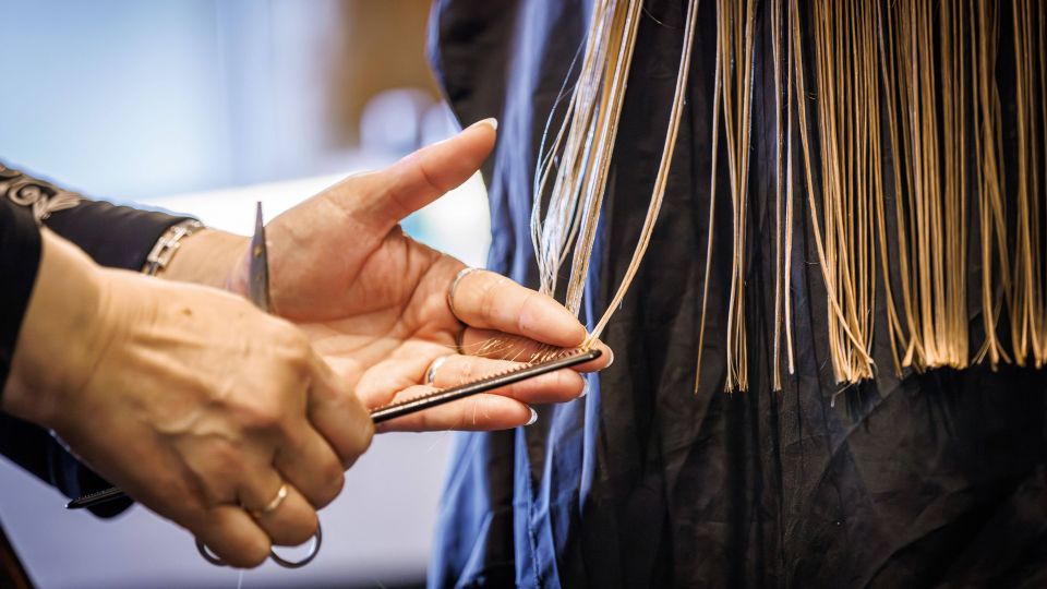 Detailaufnahme einer Hand, welche Haare schneidet