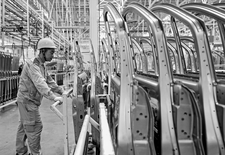 Arbeiter mit Autoteilen bei Beijing Automobile Works