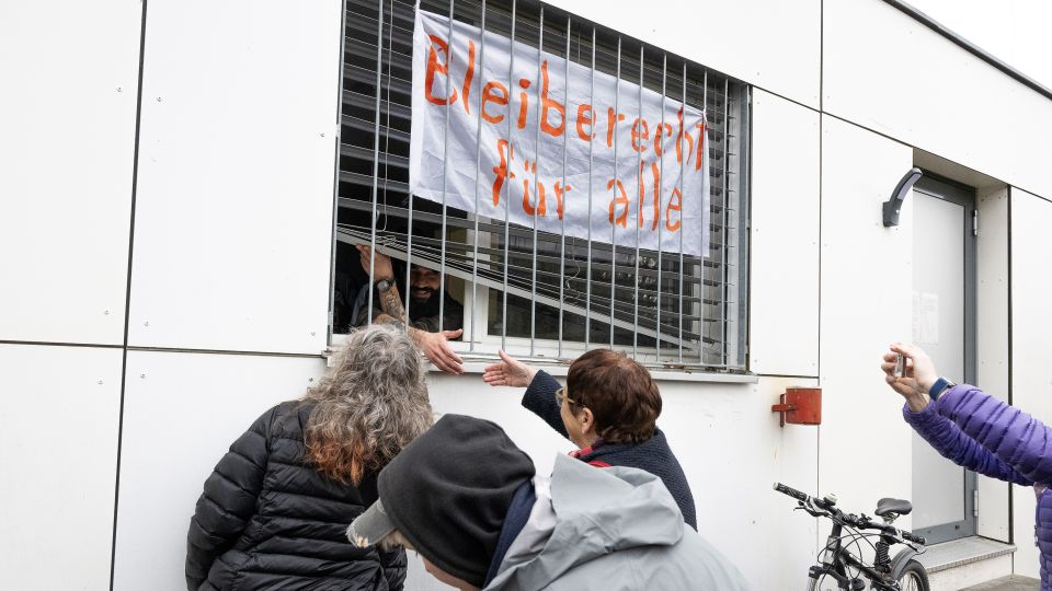 mehrere Personen protestieren vor der Notunterkunft für abgewiesene Asylsuchende in Kaltbach SZ
