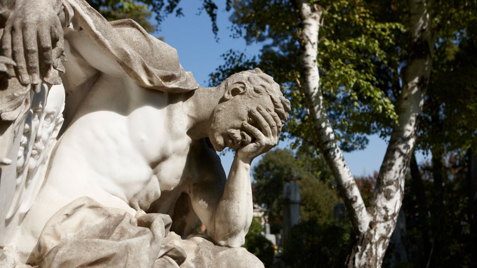 Skulptur auf dem Wiener Zentralfriedhof: ein Mann stützt seinen Kopf auf seiner Hand ab
