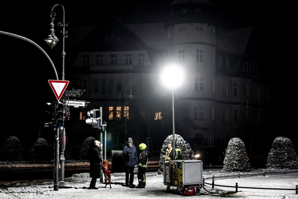 Feuerwehrleute stellen eine mobile Flutlicht-Anlage in Berlin-Zehlendorf auf