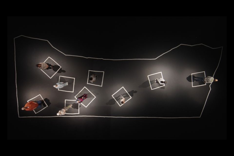 Filmstill aus «Qui vit encore»: die Protagonist:innen stehen auf einer mit Kreide gezeichneten Karte von Gaza