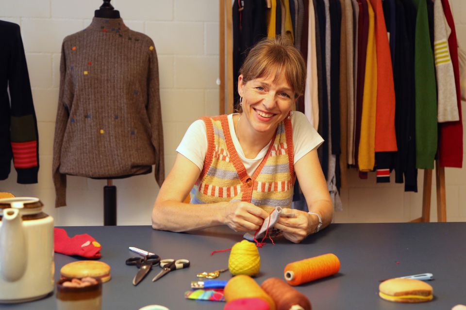 Anne Schlüter sitzt am einem Tisch mit Schneiderei-Utensilien