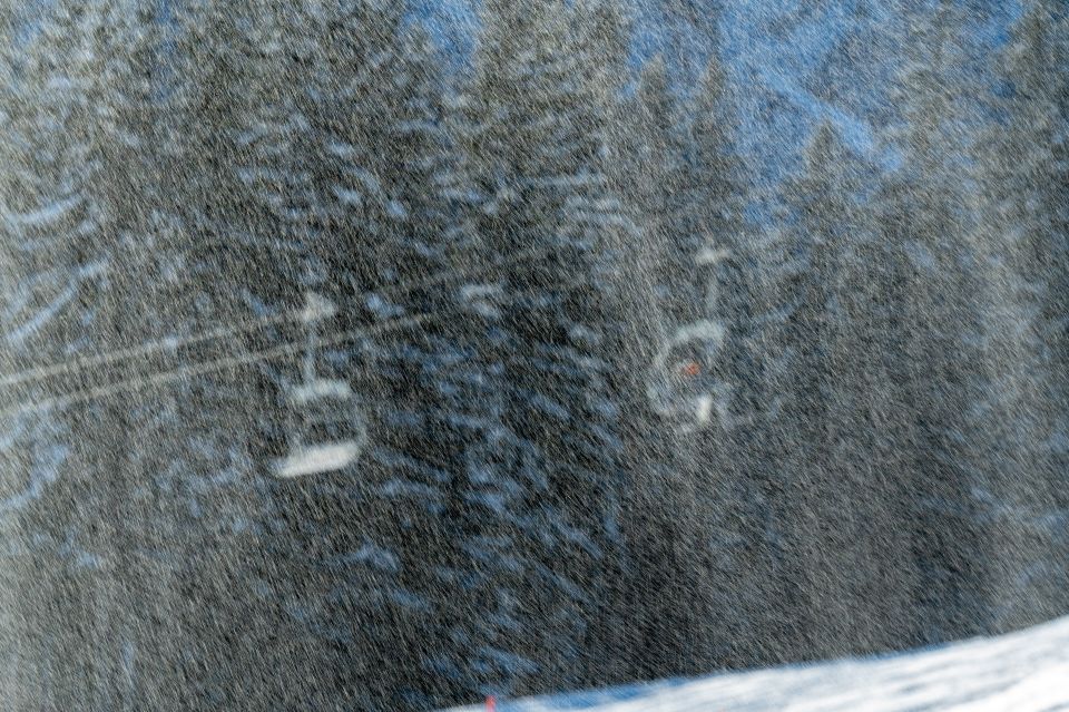 Kunstschnee in der Luft funkelt im Licht vor der Sesselbahn