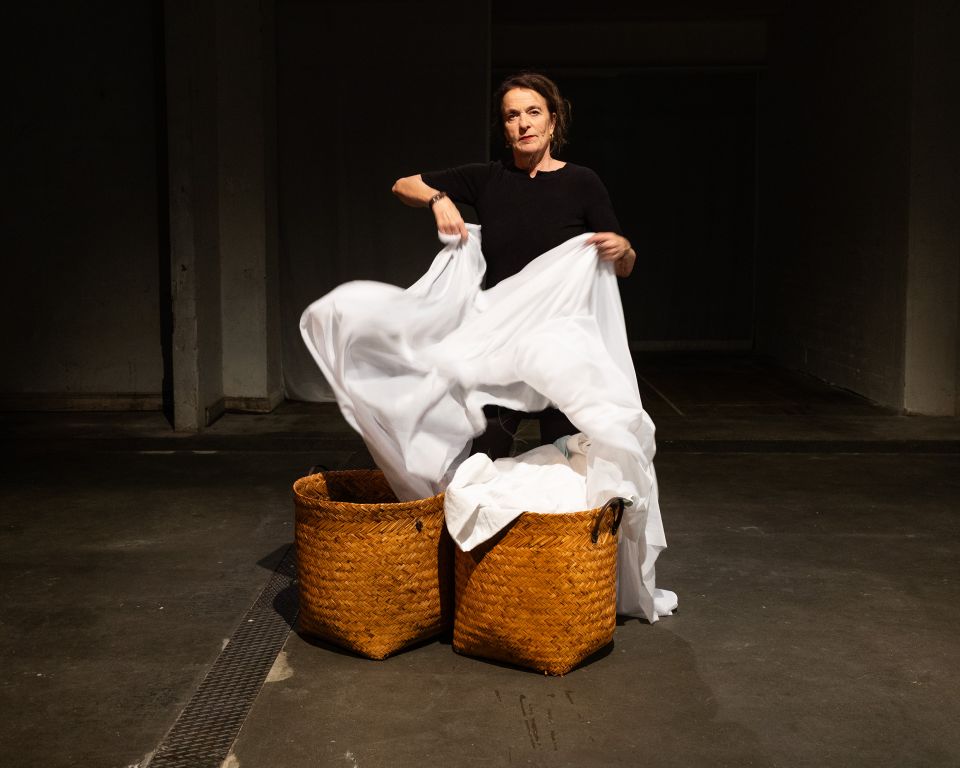 Theatermacherin Anina Jendreyko zieht zwei Tücher aus Bastkörben