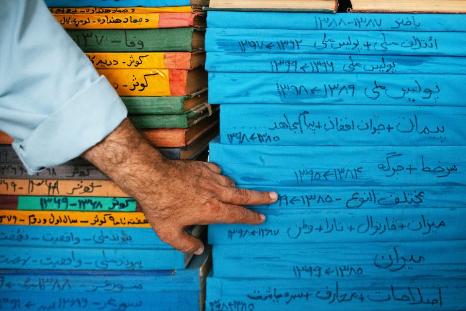 Ahmad Schah Wahdat zeigt auf ein Buch mit gebundenen Zeitungen