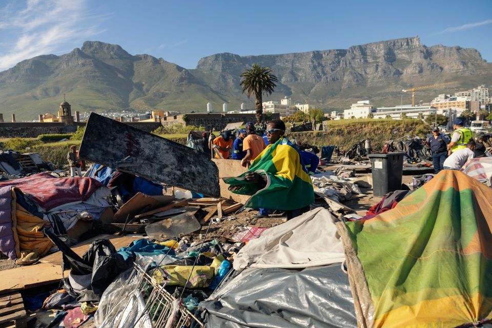 Menschen suchen nach Gegenständen nach einer Zwangsräumung im Zentrum von Kapstadt