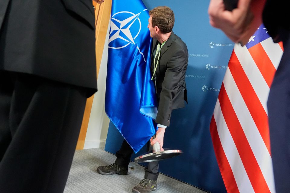 vor dem Fototermin mit US-Aussenminister Marco Rubio und dem deutschen Kanzler Friedrich Merz wird die Nato-Flagge entfernt und die US-Flagge platziert