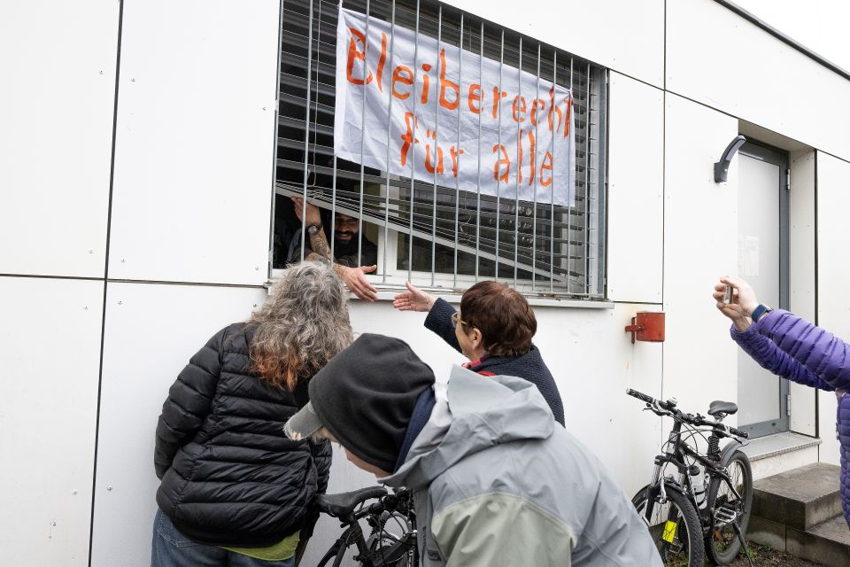 mehrere Personen protestieren vor der Notunterkunft für abgewiesene Asylsuchende in Kaltbach SZ