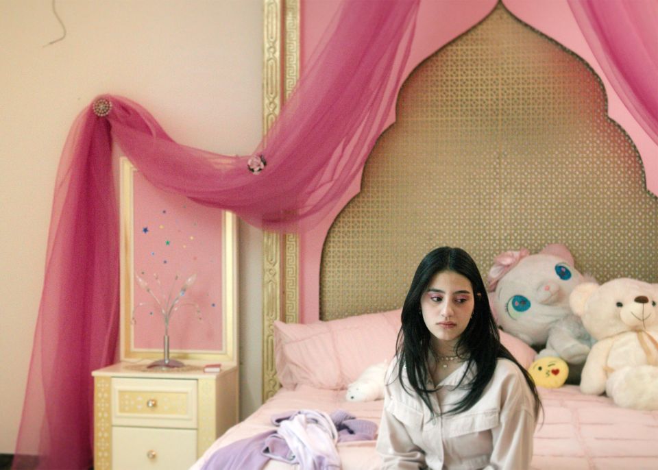 Filmstill aus «Mond»: eine junge Frau sitzt auf einem Bett