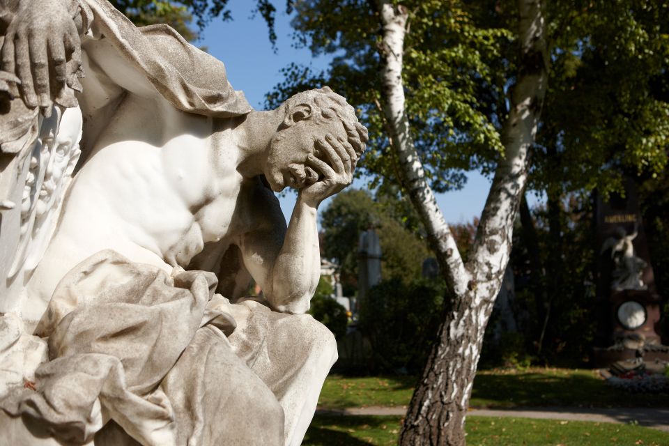 Skulptur auf dem Wiener Zentralfriedhof: ein Mann stützt seinen Kopf auf seiner Hand ab