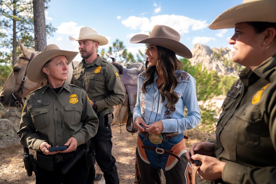 Heimatschutzministerin Kristi Noem am Mount Rushmore mit Border-Patrol-Beamt:innen