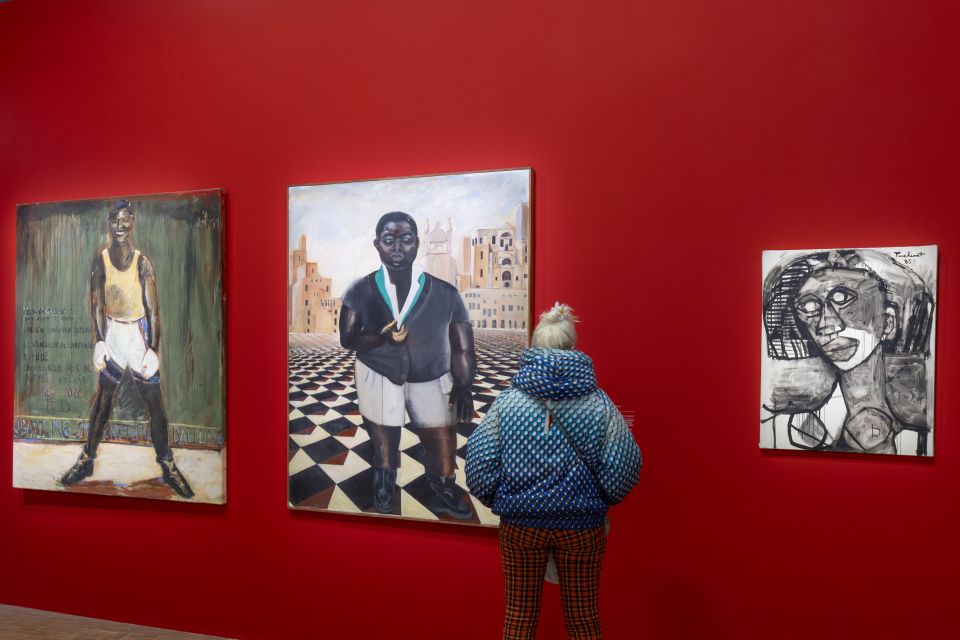 eine Person betrachtet Gemälde in der Ausstellung «Paris noir»