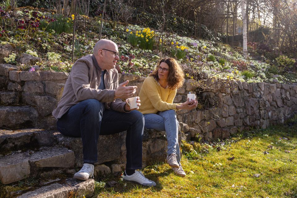 Holger Gurtner und Rahel Wenger sitzen in einem Garten und sprechen miteinander
