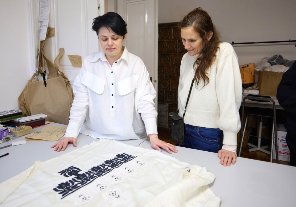 Olesia Hryn begutachet mit einer Mitarbeiterin einen bedruckten Stoff