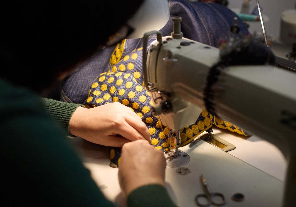 Modedesignerin Olesia Hryn sitzt an der Nähmaschine