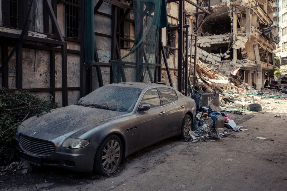 ein Auto welches neben einem zerstörten Gebäude steht