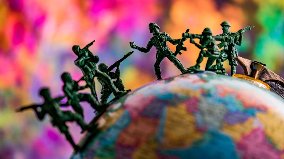 Symbolbild: Spielzeug-Soldaten auf einem Globus