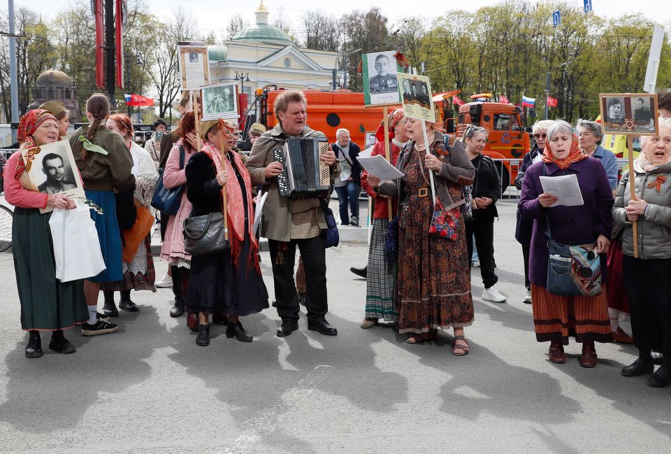 Menschen mit Porträts ihrer Vorfahren ziehen singend durchs Stadtzentrum in St. Petersburg