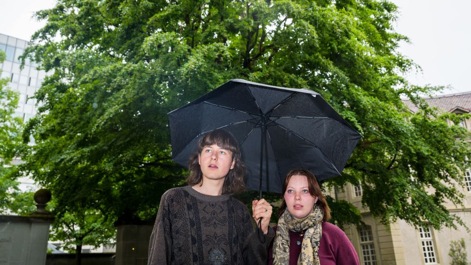 Moritz Wülser und Jael Seiler stehen unter einem Regenschirm beisammen
