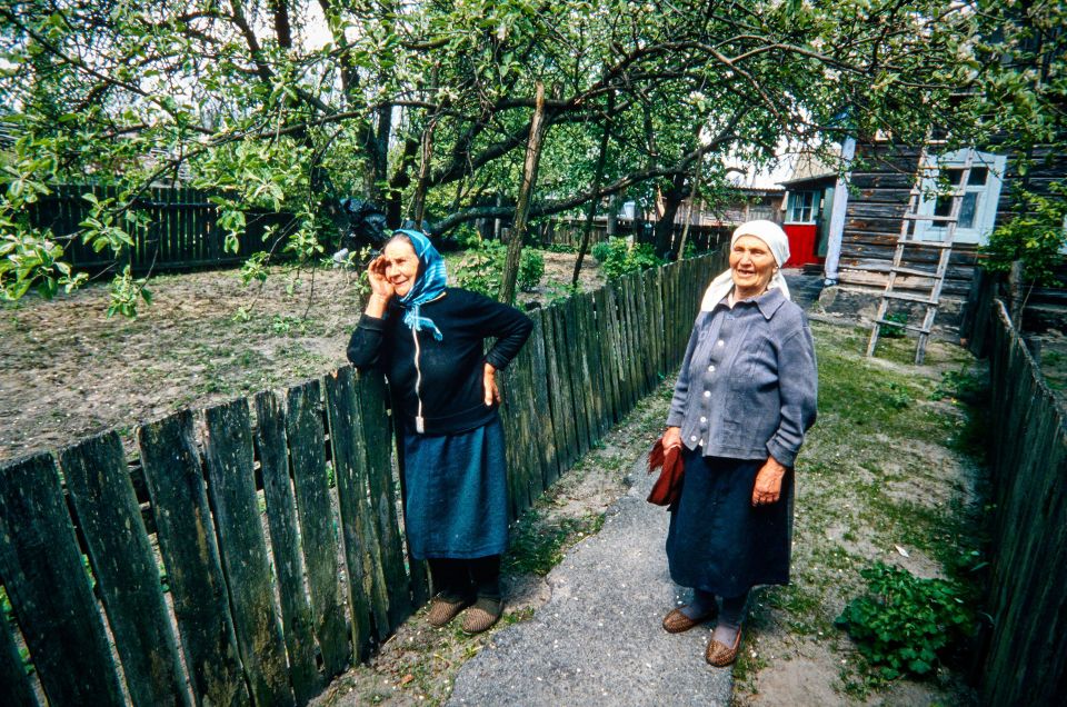 eine ältere Frau und ihre Nachbarin bei ihren Häusern in der Sperrzone bei Tschernobyl
