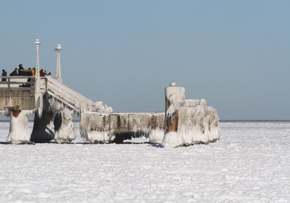 Menschen auf einem vereisten Anlegesteg auf der Insel Usedom im Jahr 2021