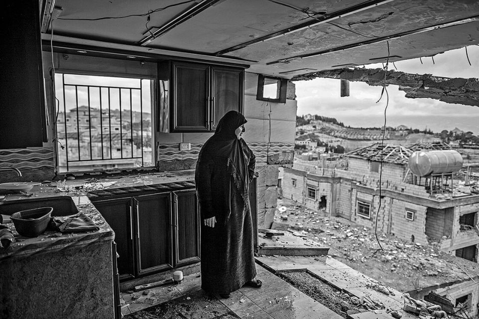eine Frau in einem von Israel zerstörten Gebäude in Nabi Chit
