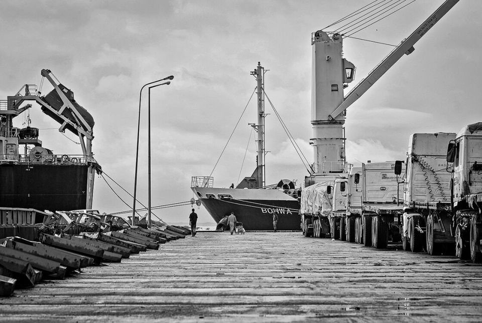 Lastwagen und Schiffe im Hafen von Bissau