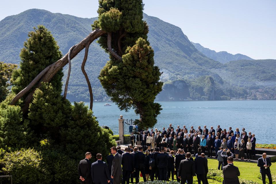 Politiker:innen stehen für ein Gruppenfoto vor dem Luganersee zusammen