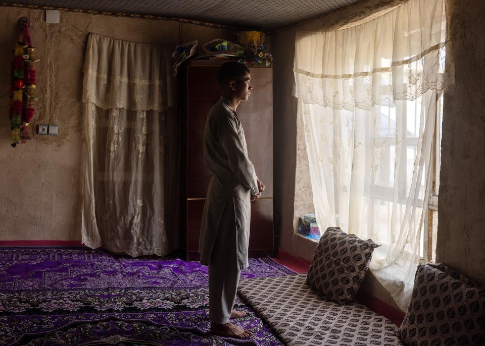der Jugendliche Mohamed Nur der Hasara-Ethnie schaut durch ein Fenster mit Vorhang