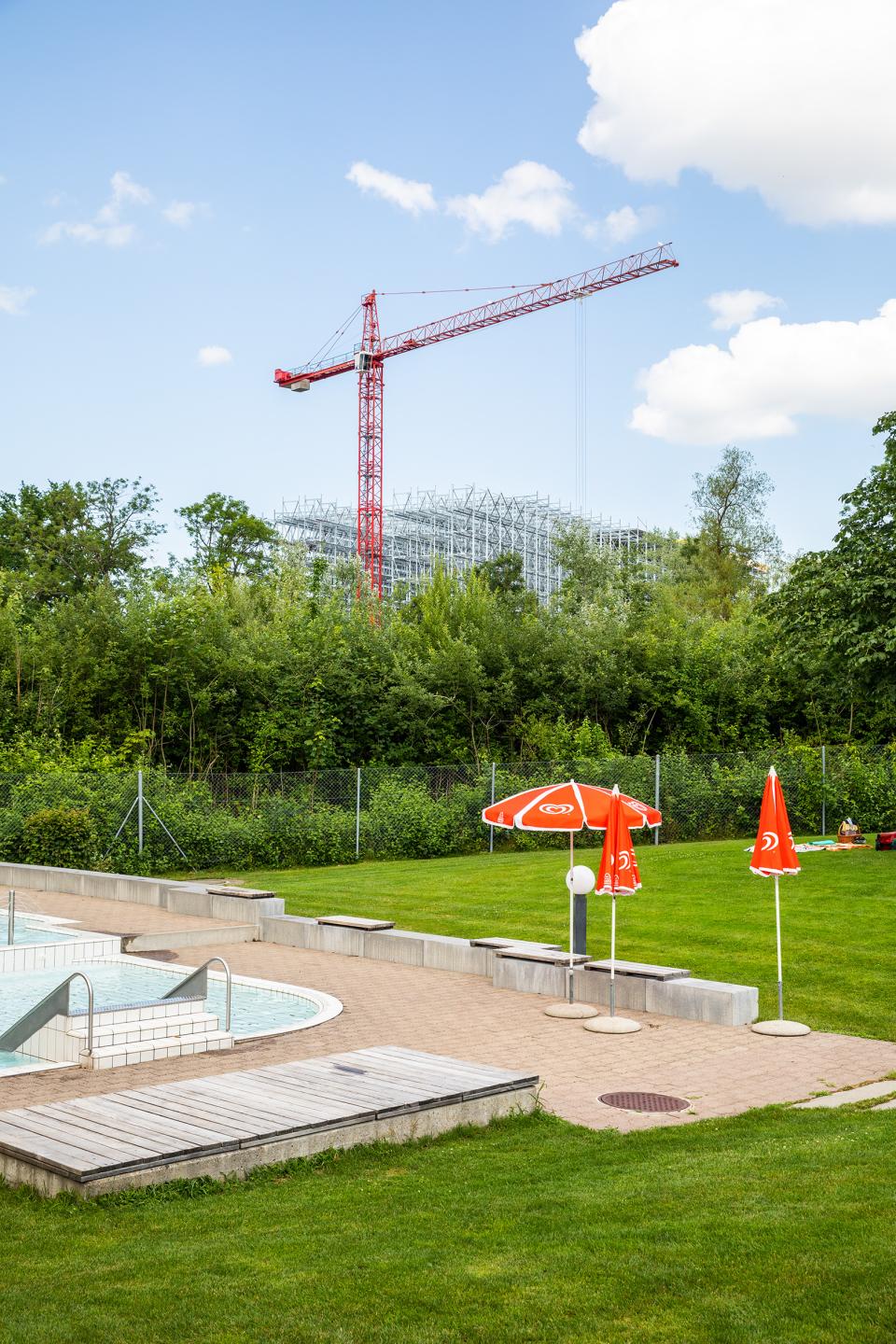 Liegewiese und Schwimmbecken der Badi Suhr umgeben vom Industriegebiet