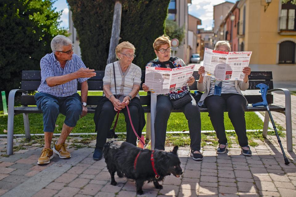 vier Senior:innen bei der Lektüre der Parteizeitung auf einer Sitzbank