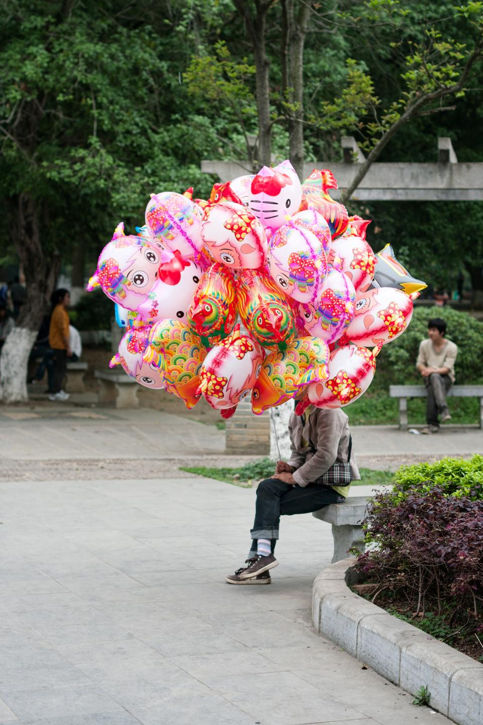 Person welche viele Luftballons in der Hand hält