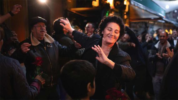 Filmstill aus «Crossing»: eine Frau tanzt unringt von Menschen