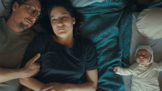 Filmstill aus «Mother’s Baby»: eine Frau und ein Mann liegen zusammen mit einem Baby auf einem Bett