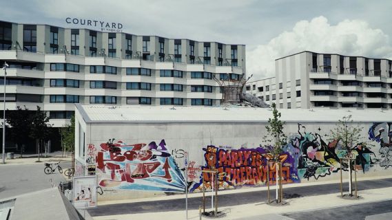 Filmstill aus «Asphalte Public»: Grafittis an Wand eines Gebäudes
