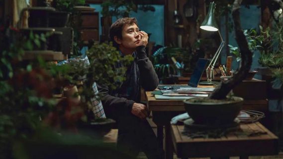 Filmstill aus «No Other Choice»: eine Person sitzt vor einem Laptop und grübelt