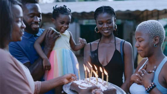 Filmstill aus «Promis le ciel»: eine Gruppe von Meschen feiert Geburtstag mit Kerzen auf einer Geburtstagstorte